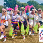 Group of girls dressed as Morris dancers holding coloured hankies